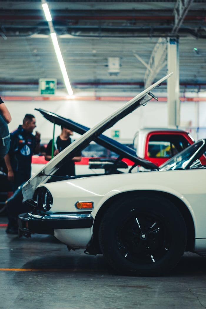 Crafting Captivating Headlines: Your awesome post title goes here Classic car with open hood in a workshop, showcasing mechanical work and vehicle maintenance.